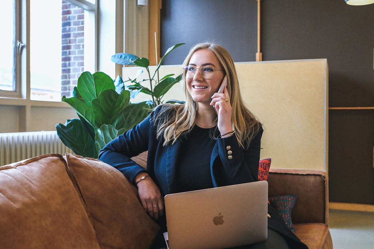 Woman in blue long sleeve shirt using silver macbook