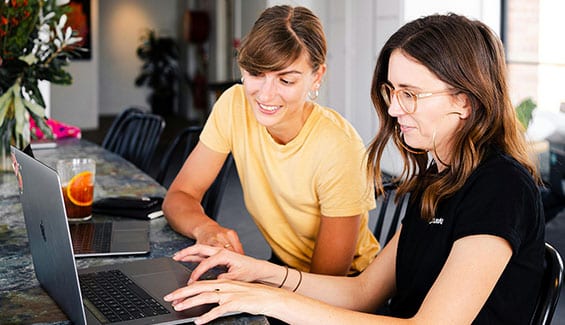 Two girls working in front of a laptop