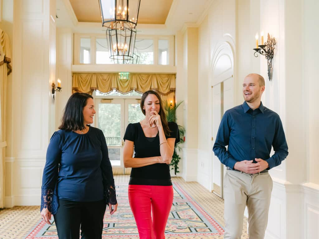 Three members of the Aha Media Group team walking in a hallway and talking.