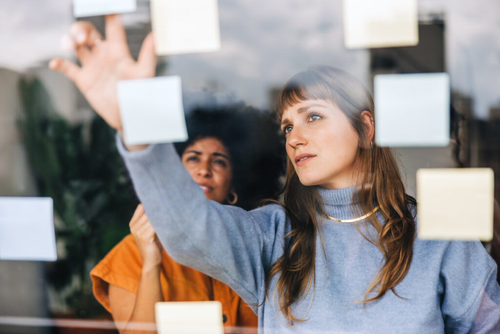 businesswomen brainstorming using sticky notes