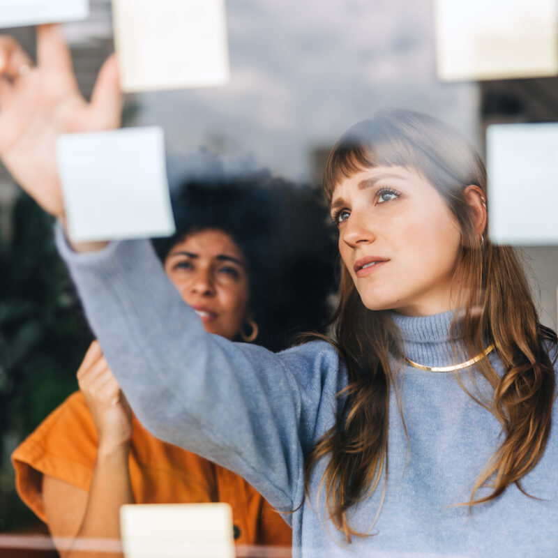 businesswomen brainstorming using sticky notes