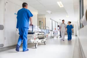 Nurse pushing gurney through hospital hallway