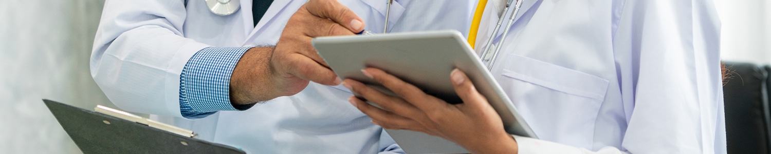 two doctors reviewing notes on tablet