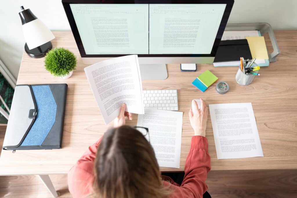 top view of workspace and woman working at computer