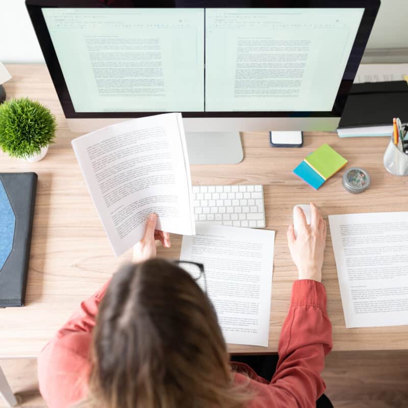 top view of workspace and woman working at computer